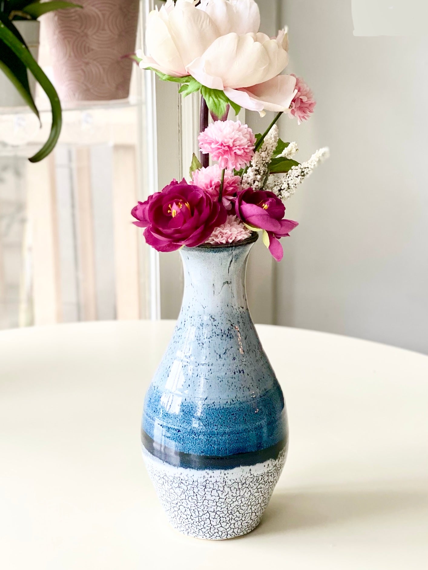 Vase 10.75”, A tall, elegant handmade vase with soft gradient glazes of sky blue, deep ocean blue, black, and crackled white (discounted for small crack underneath, normally $125)