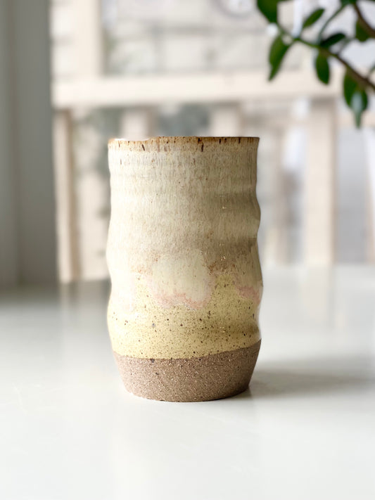 Tumbler, 16oz, no.19, A soft creamy white glaze fading into warm butter yellow with a blush of pink at the transition, breaking gently over the rustic, sandy clay base.